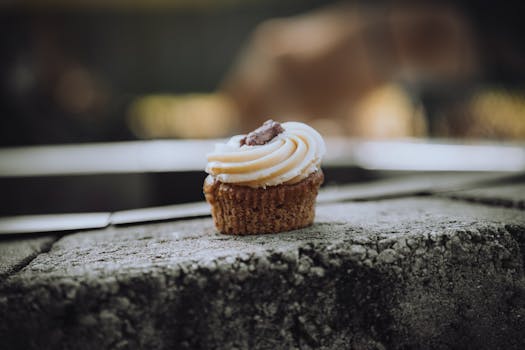 Tasty cupcake with creamy frosting on a concrete surface, perfect for dessert themes.