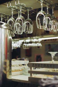 Stylish bar interior featuring hanging glassware and clean countertops under warm lighting.