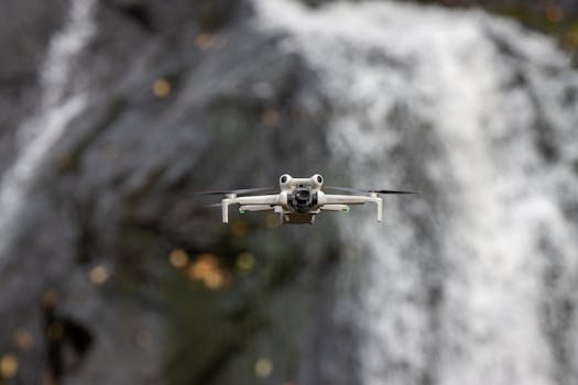 A drone captured mid-flight against a stunning waterfall backdrop in Sweden, showcasing technology in nature.