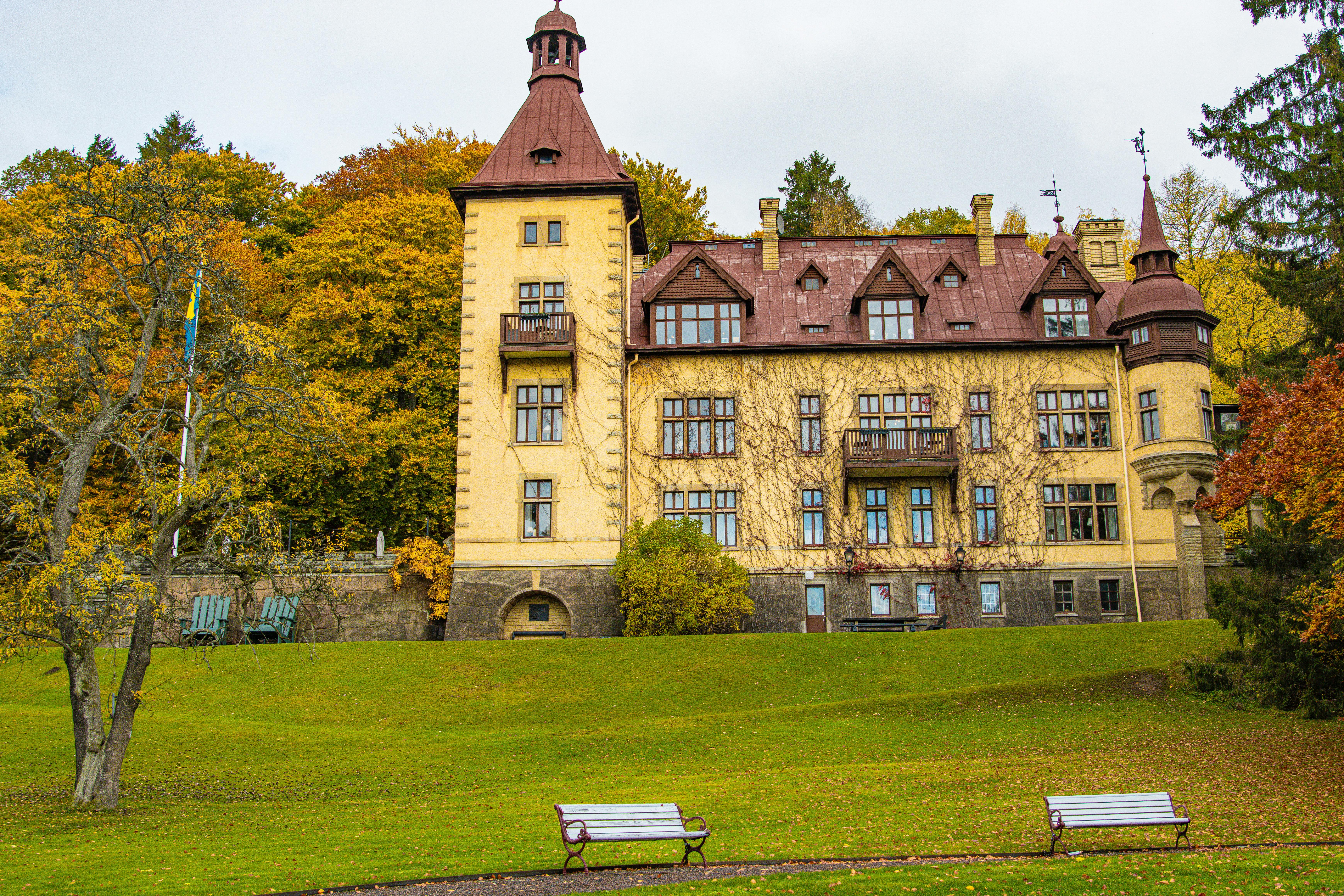A picturesque historic building in Huskvarna, Sweden, set against vibrant autumn leaves.