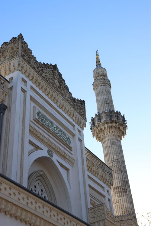 Free Close-up of an intricately designed mosque and towering minaret against a clear sky. Stock Photo