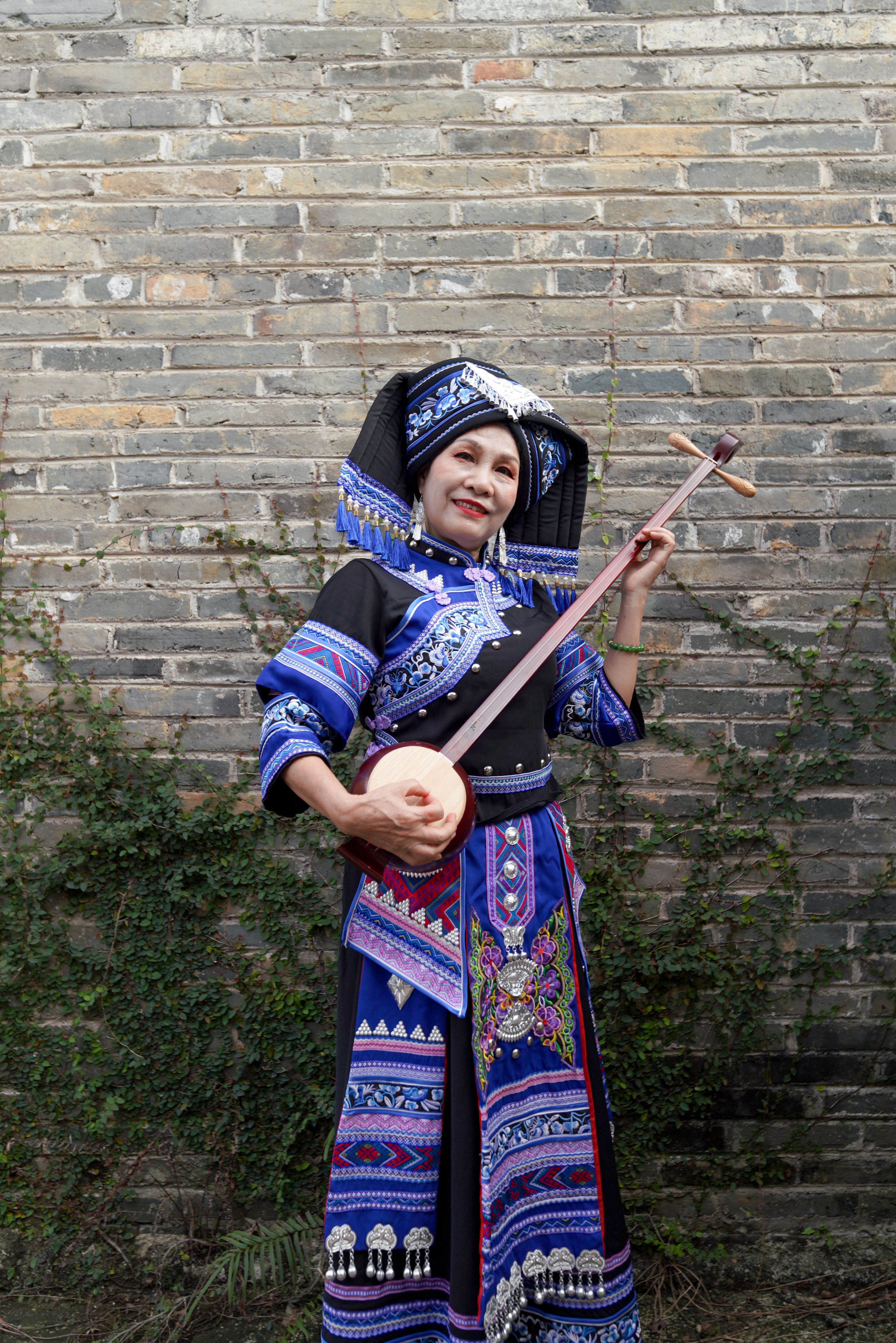 Traditional Zhuang Woman Playing String Instrument · Free Stock Photo