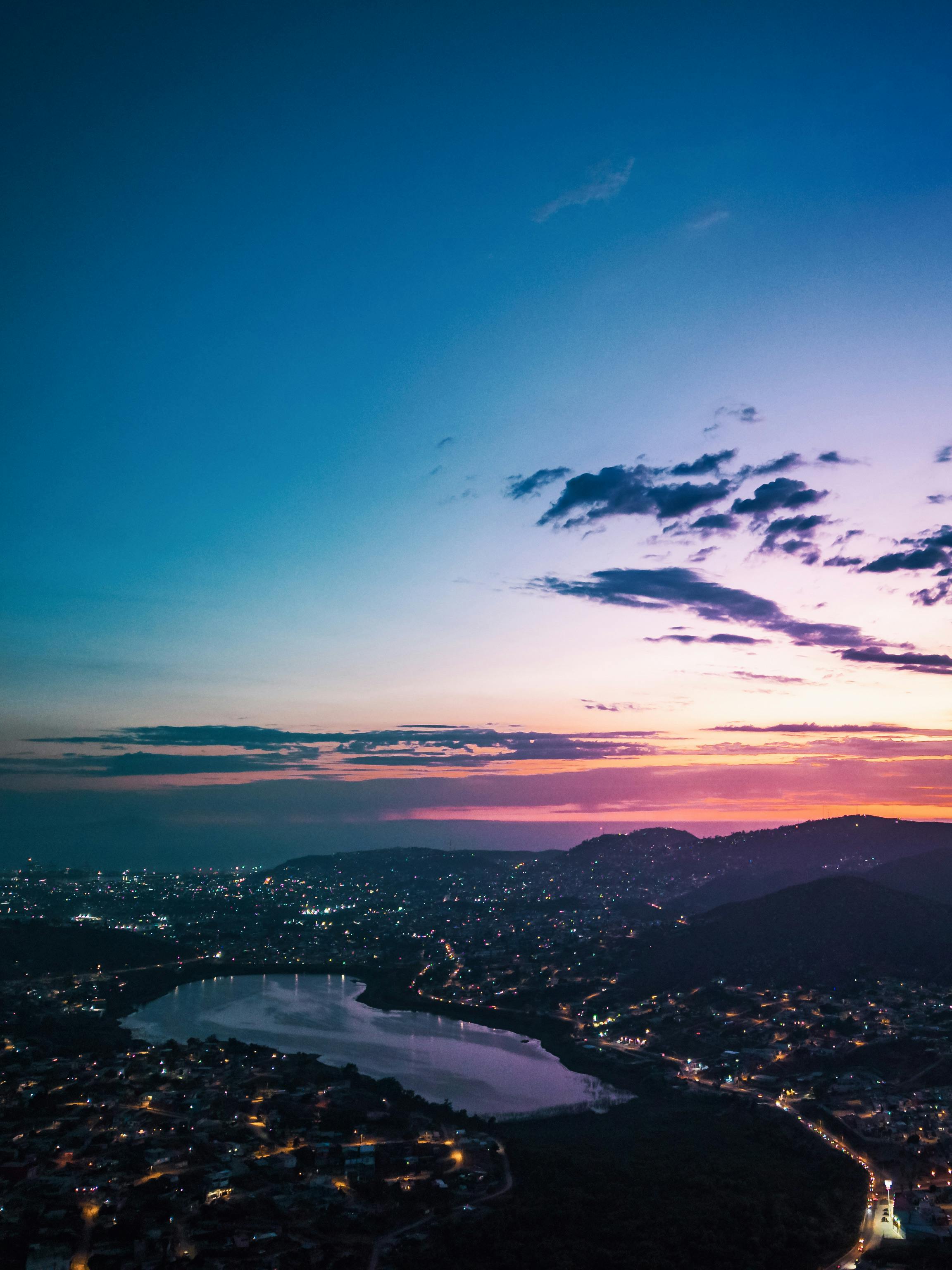 Kostenlos Ein atemberaubender Luftblick auf die Skyline einer Stadt in der Abenddämmerung mit leuchtenden Farben. Stock-Foto