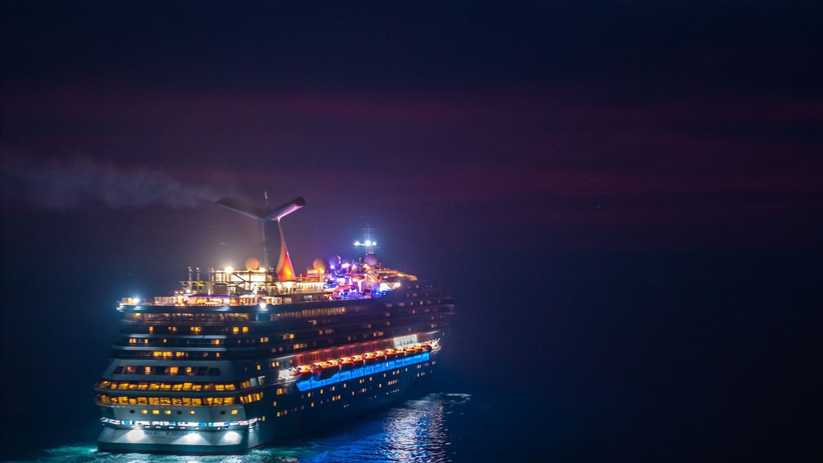 夜の海を進む明るいクルーズ船