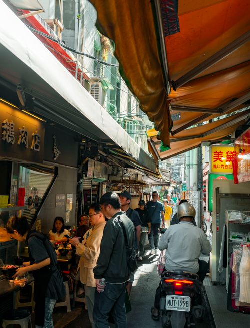 Free Vibrant street market scene in Taipei, Taiwan, showing people and shops bustling with activity. Stock Photo
