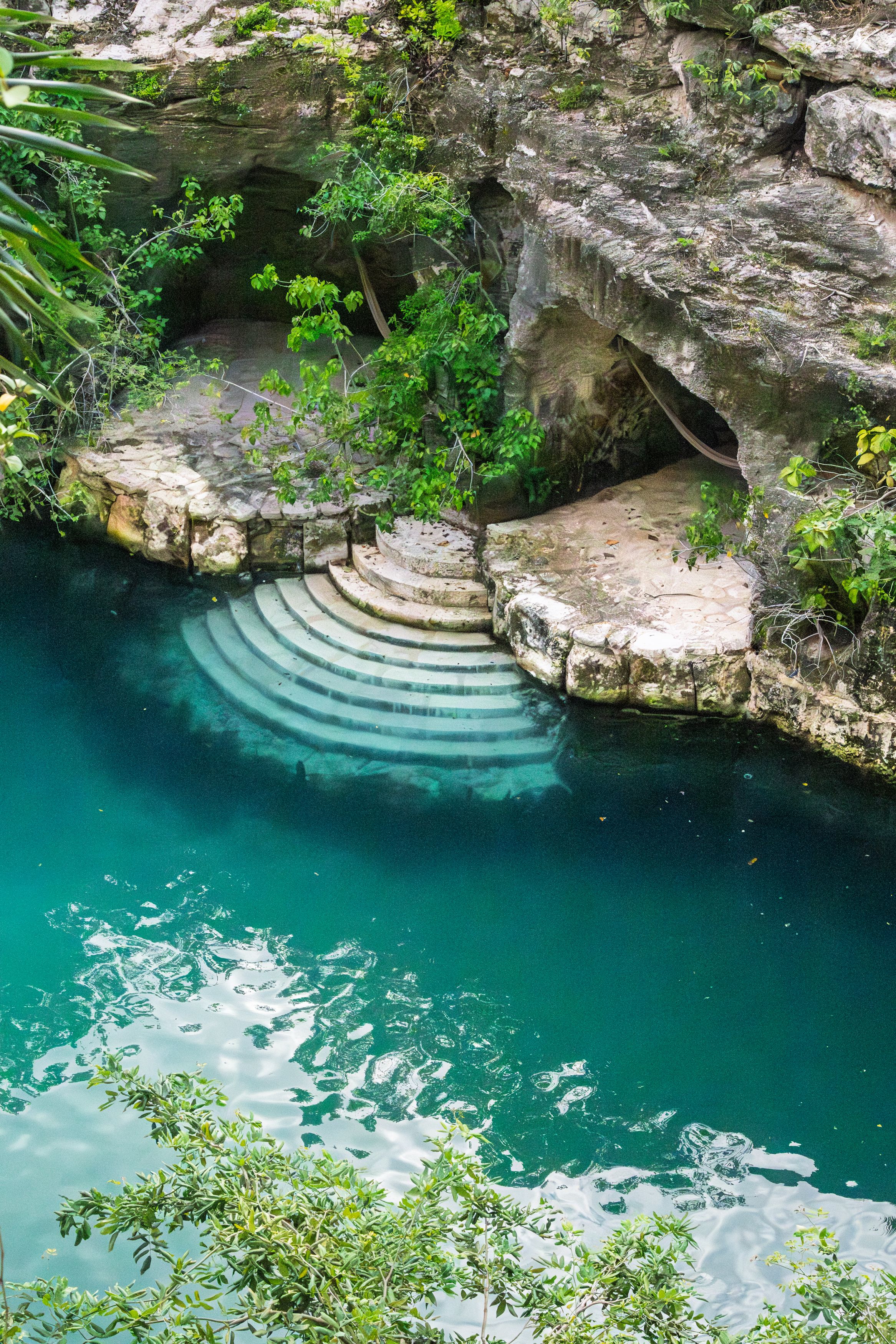 Cénote aux eaux turquoise entouré de végétation dans le Quintana Roo