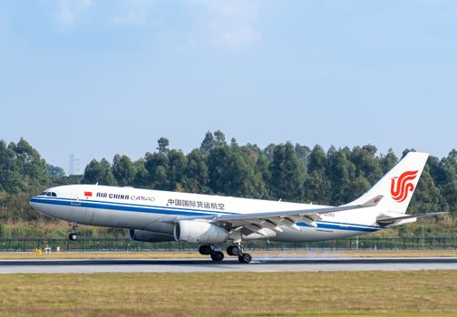 Air China Cargo aircraft lifting off against a clear blue sky at an airport.