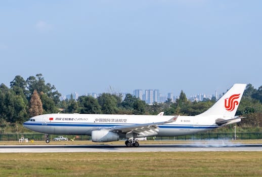 Air China Cargo airplane touching down on a runway with city skyline in the background.