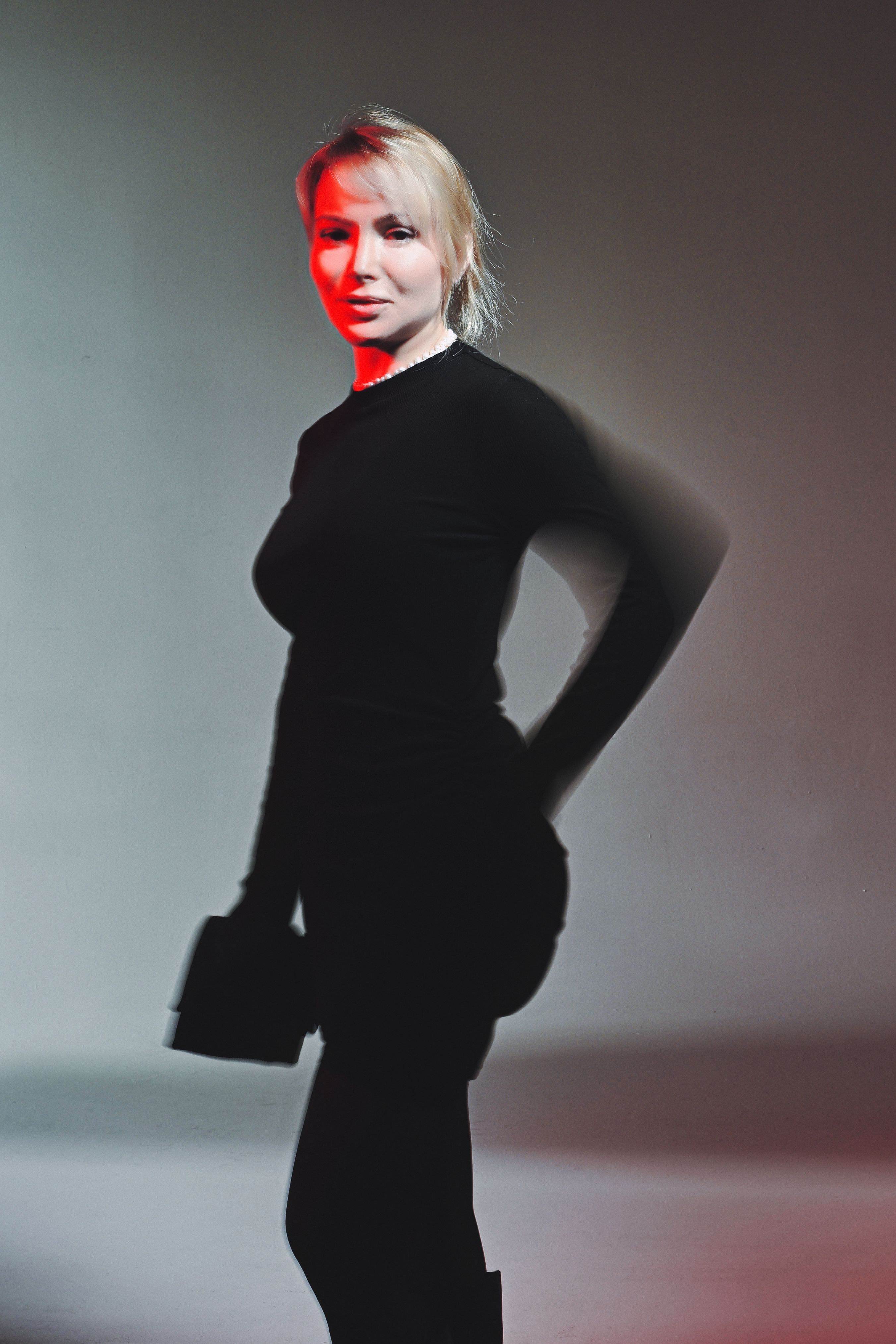 Stylish portrait of an adult woman with dramatic red lighting effect.