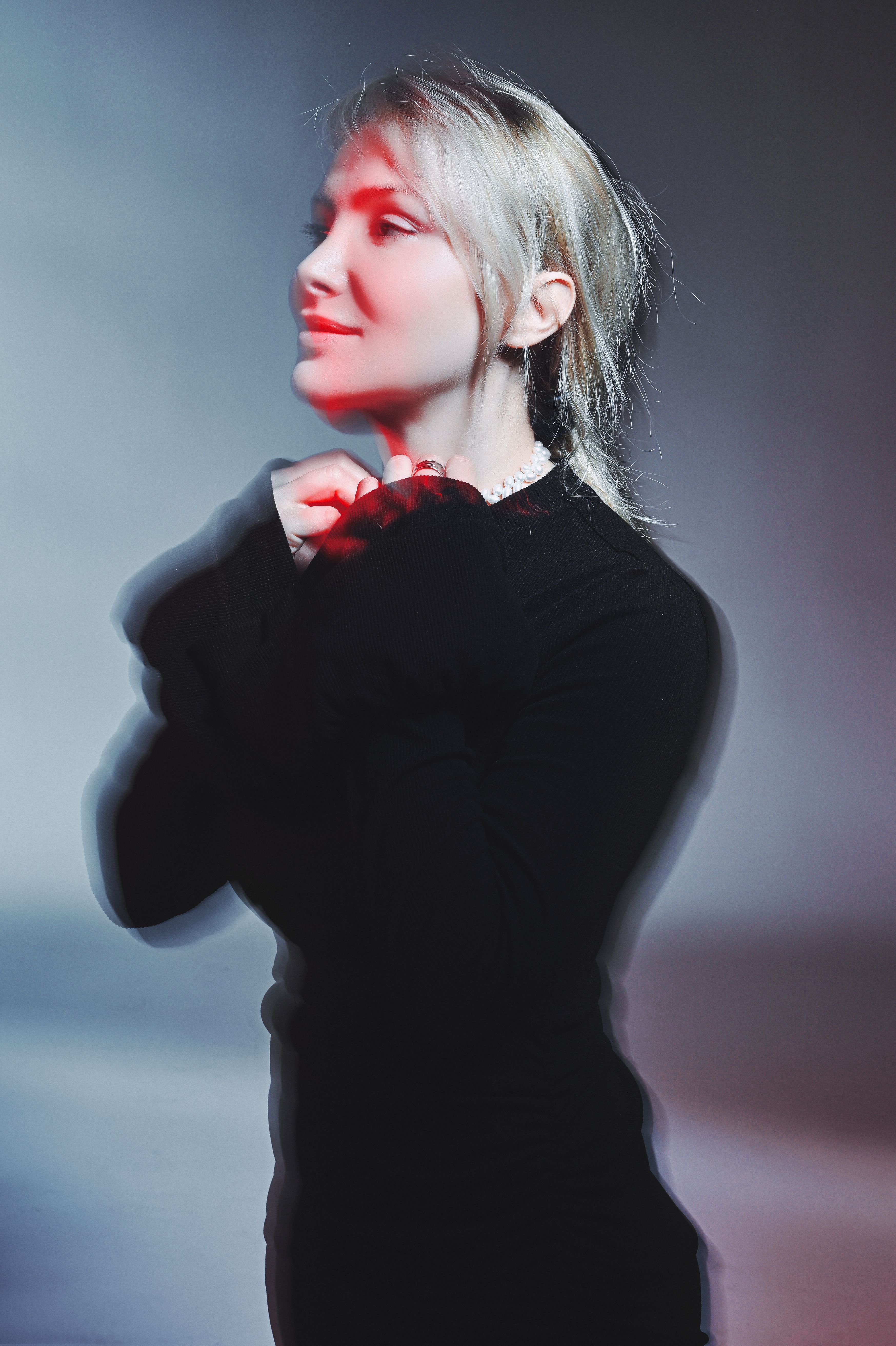 A captivating artistic portrait of a woman with blurred motion and red lighting effect capturing a dreamy atmosphere.