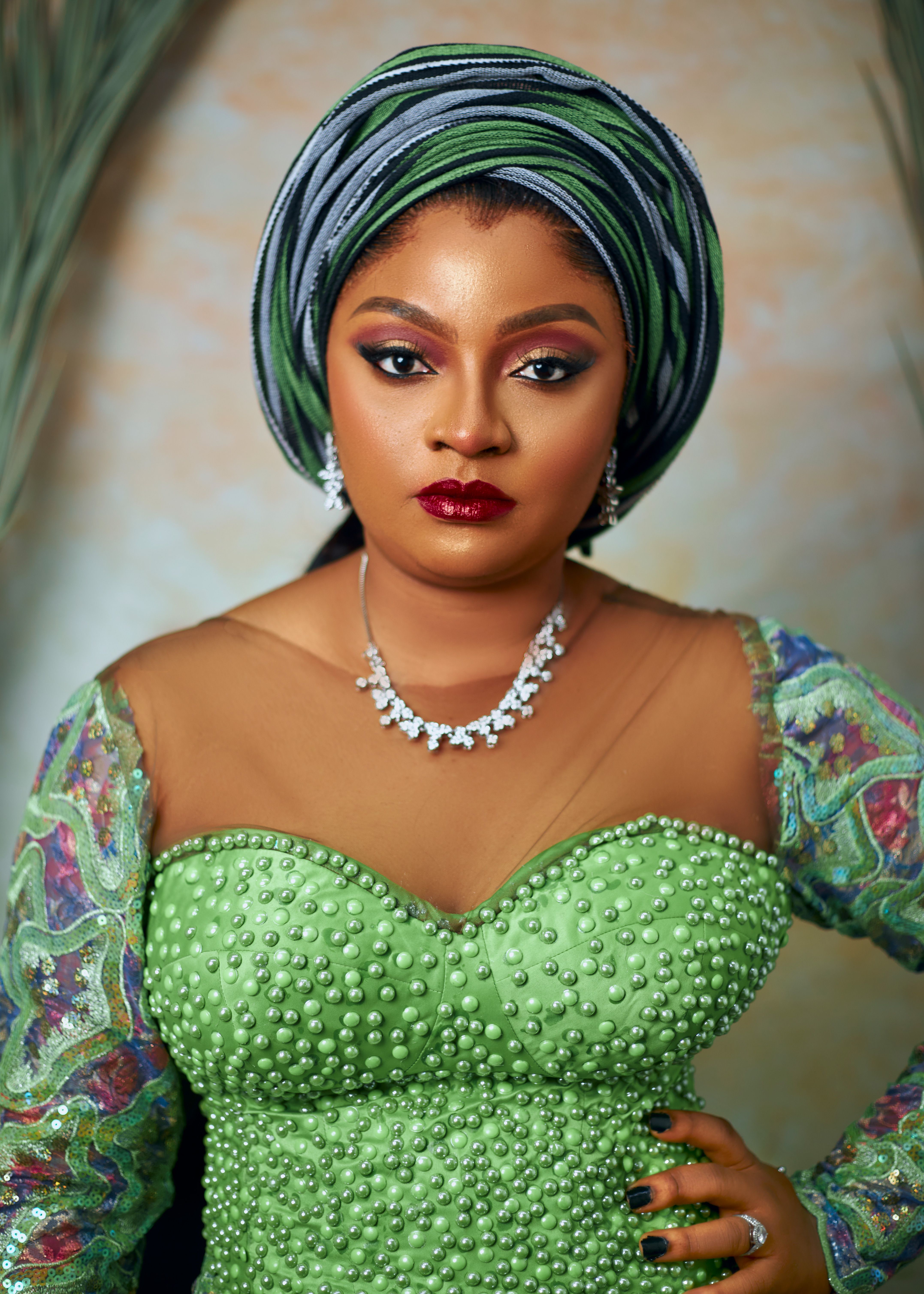 A striking portrait of a young woman in intricate traditional green attire and elegant jewels.