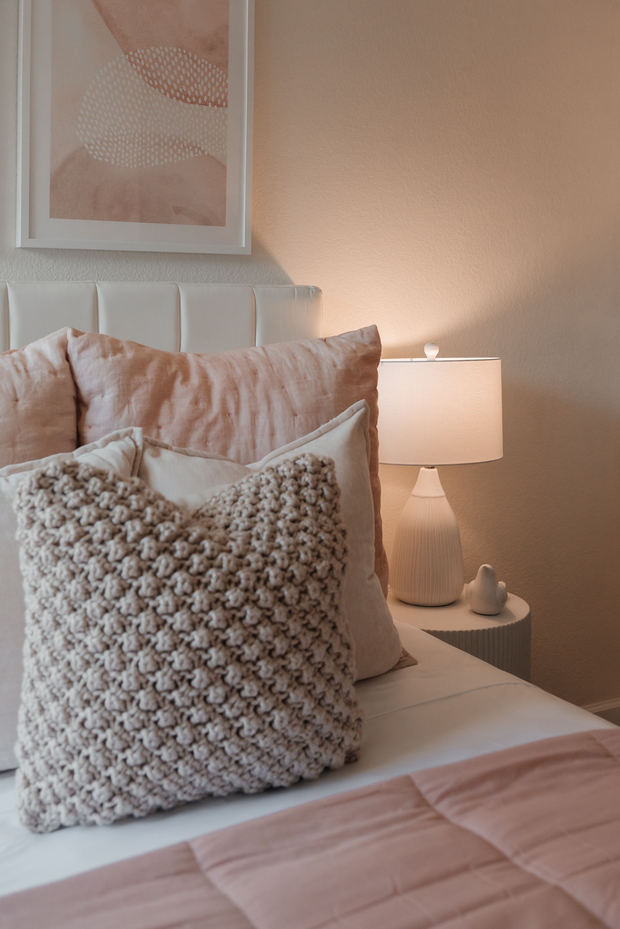 Bedroom lit by warm layered lamps