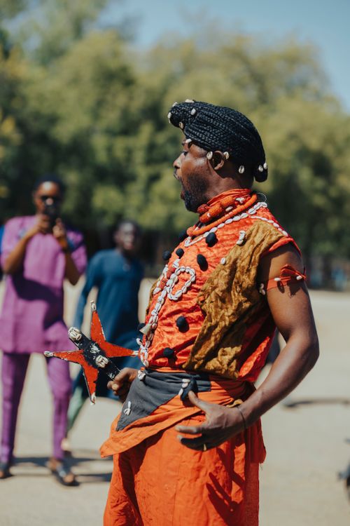 Free Vibrant traditional African dance performed outdoors with cultural attire and audience. Stock Photo