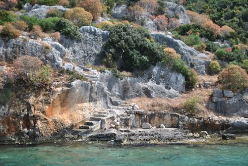 Free Scenic view of ancient stone steps carved into rocky coastal cliffs surrounded by lush vegetation. Stock Photo