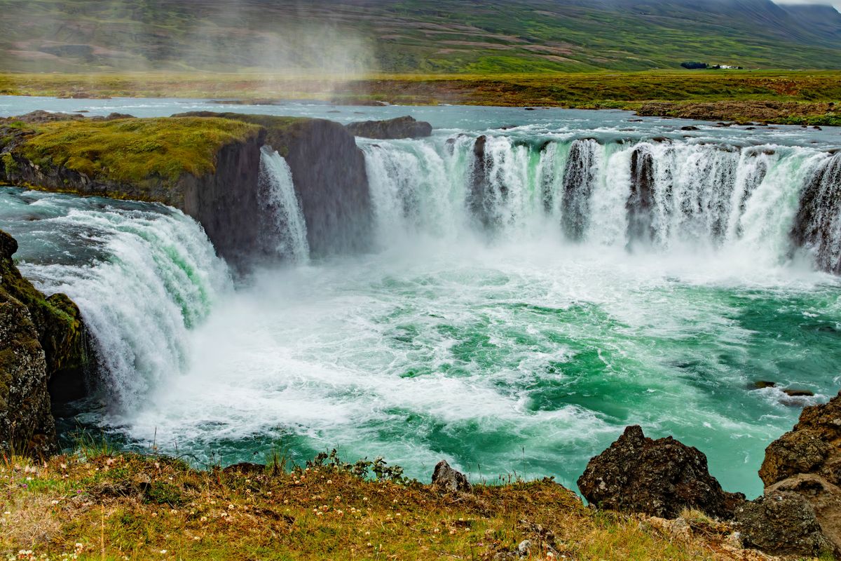 Cascada lata cu peisaj verde in jur
