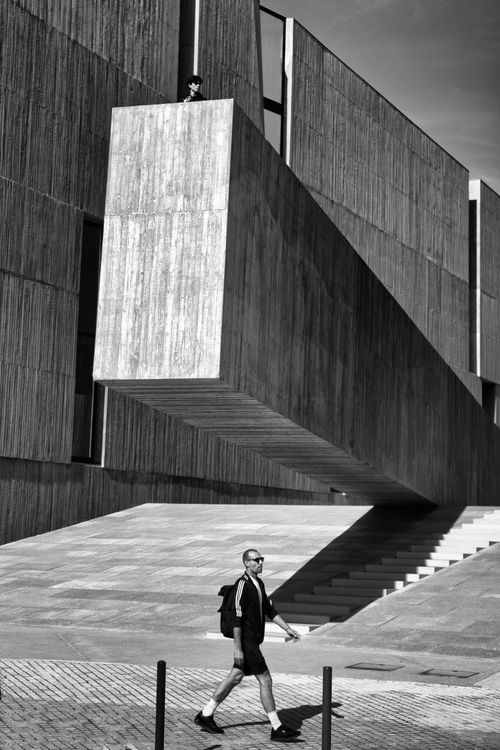 Free Striking black and white photo of modern architecture in Lisbon with a man walking by. Stock Photo