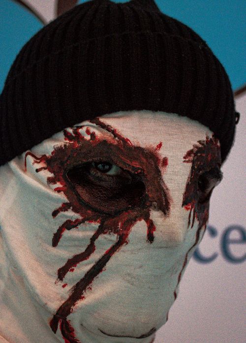Free Eerie portrait of a masked person with dark makeup creating a haunting appearance. Stock Photo