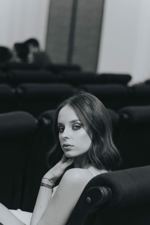 Free Graceful woman posing indoors in a black and white photograph capturing elegance and style. Stock Photo