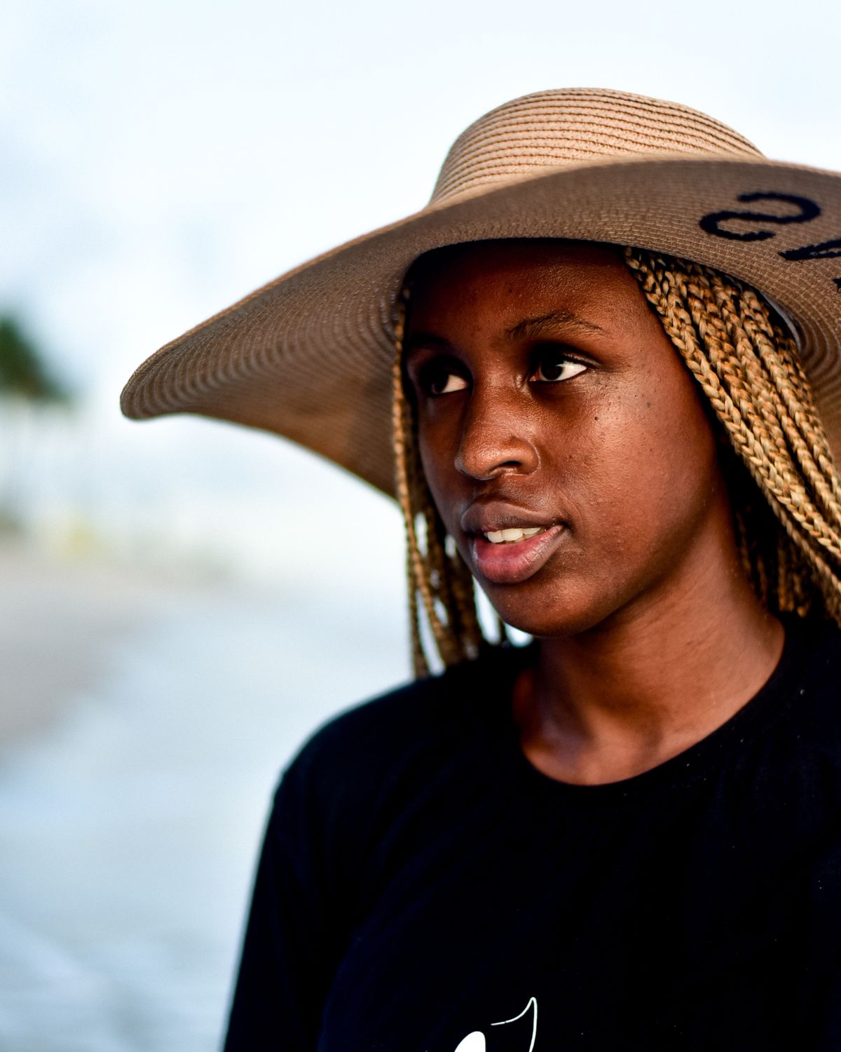 Woman wearing a wide-brim straw sun hat at the beach