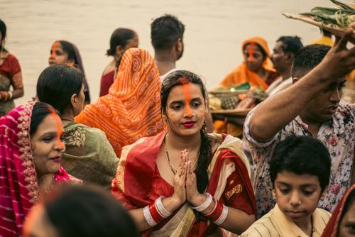 Free Women and men partaking in a vibrant cultural festival by a river, in traditional attire. Stock Photo