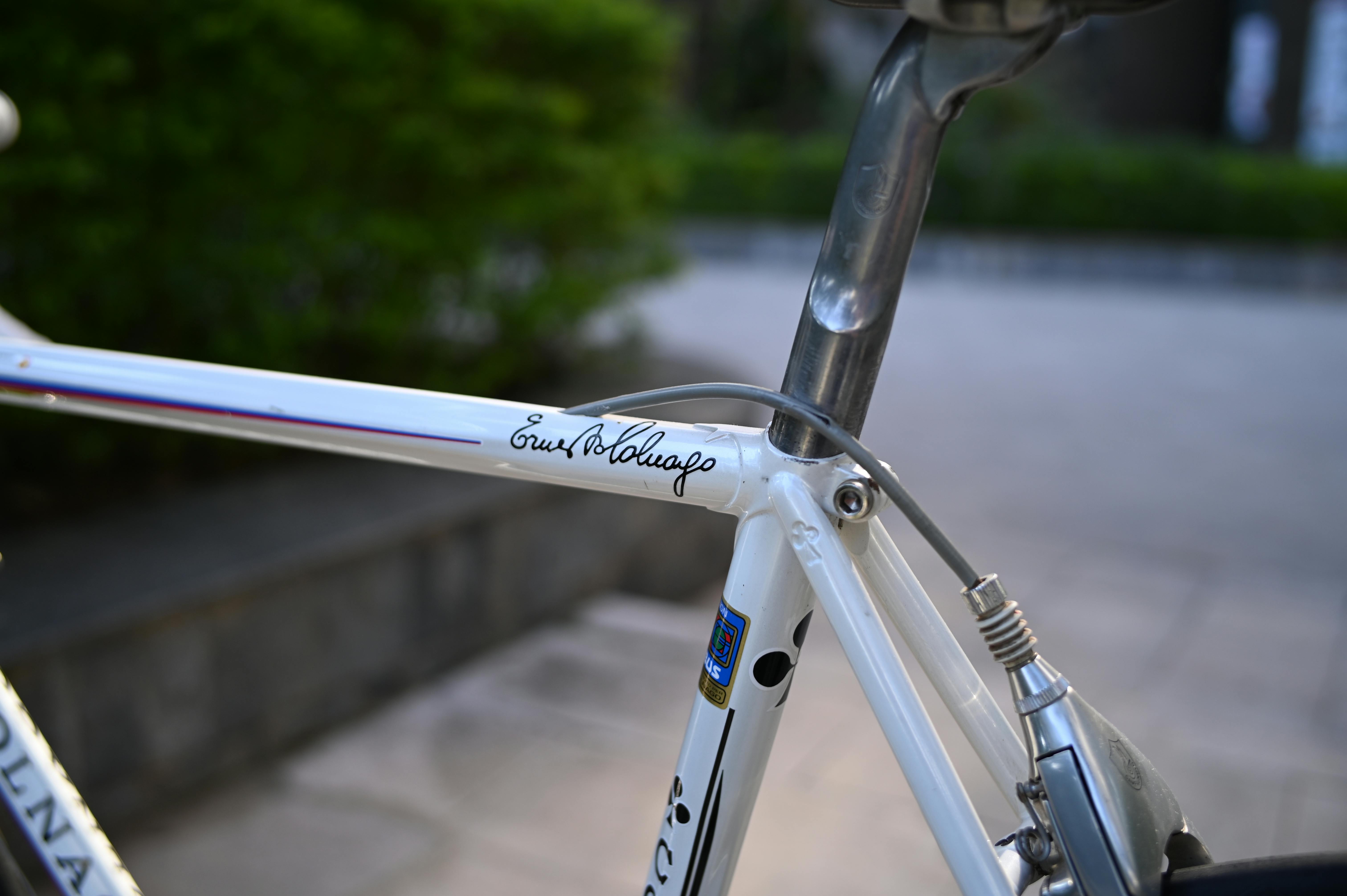 Detailed view of a vintage Colnago bicycle frame with signature, captured outdoors.