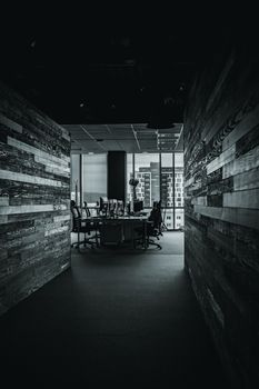 Black and white photo of a modern office interior with an urban skyline view.
