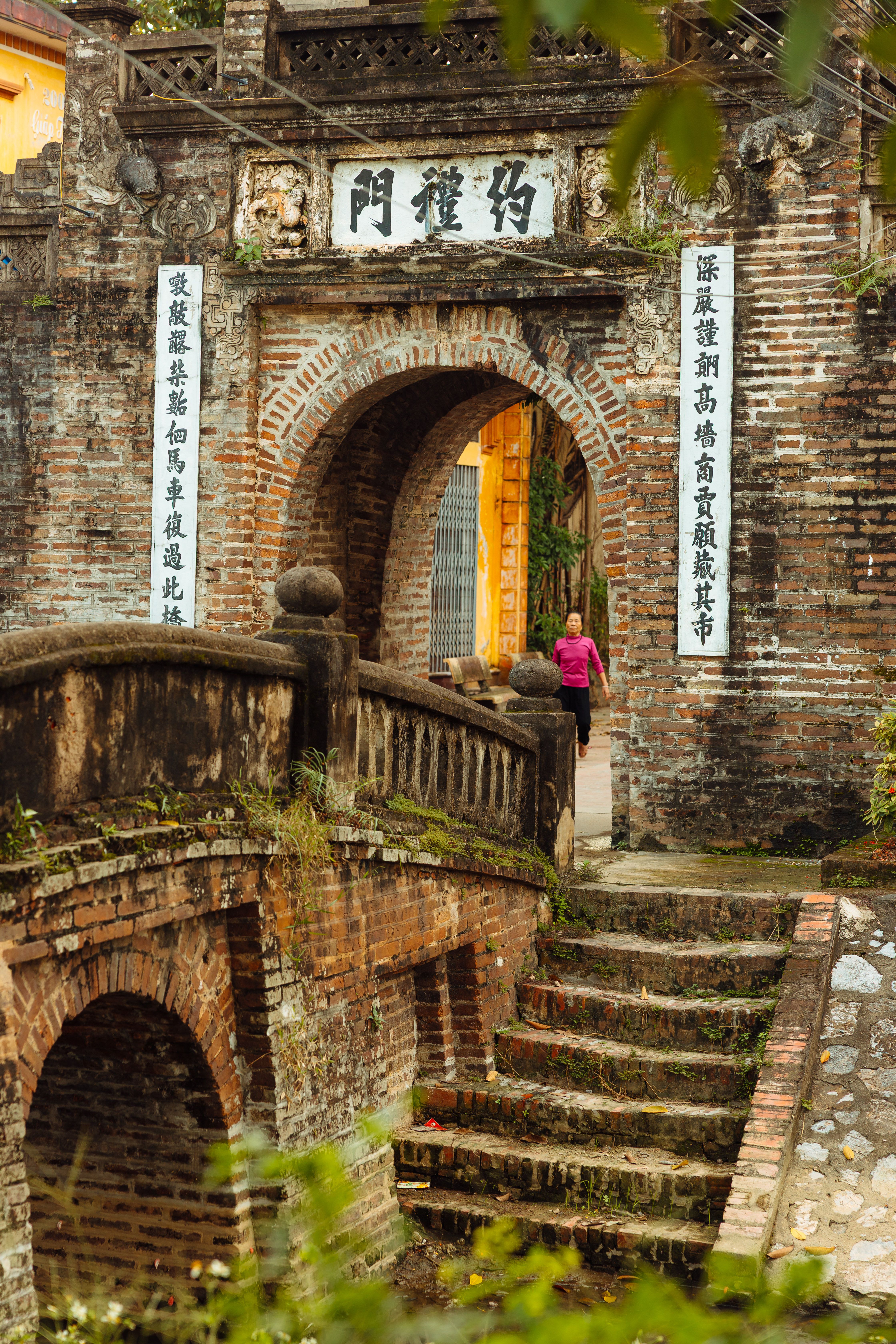 Una puerta de la ciudadela de Hue con su inscripción tallada, enmarcada por hojas