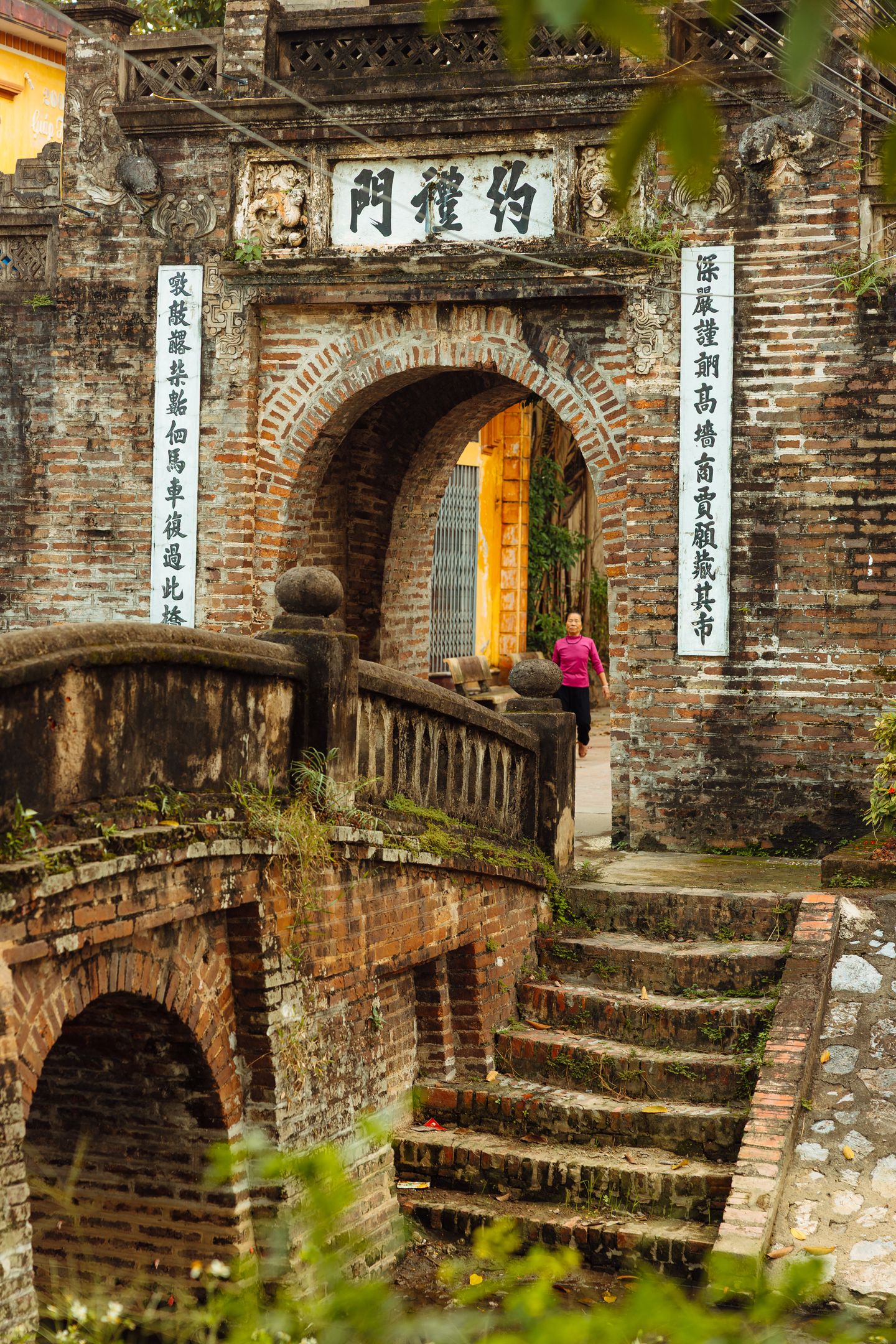 Una puerta de la ciudadela de Hue con su inscripción tallada, enmarcada por hojas