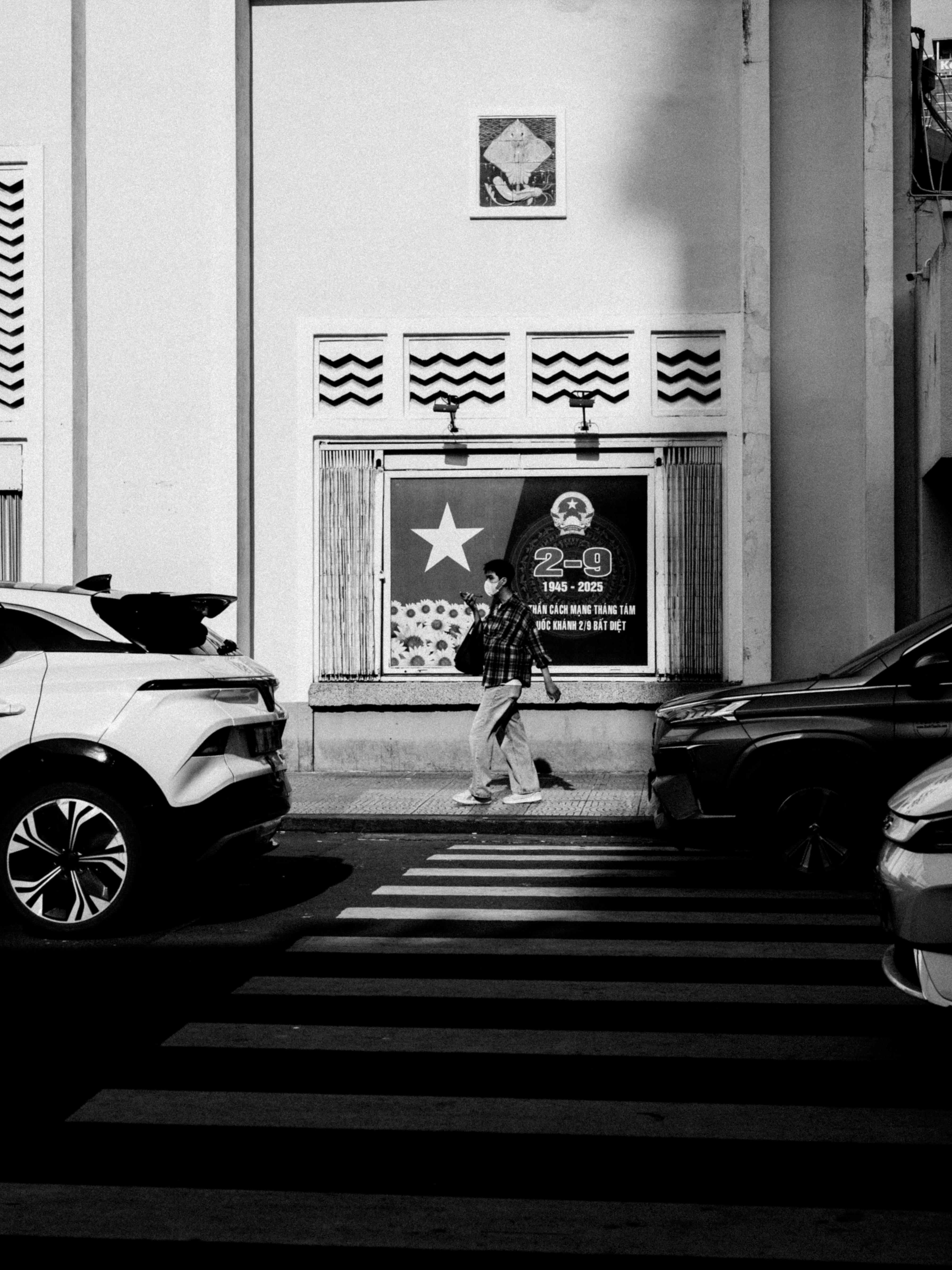 De franc Escena urbana monocroma que mostra un pas de vianants entre dos cotxes aparcats. Foto d'estoc