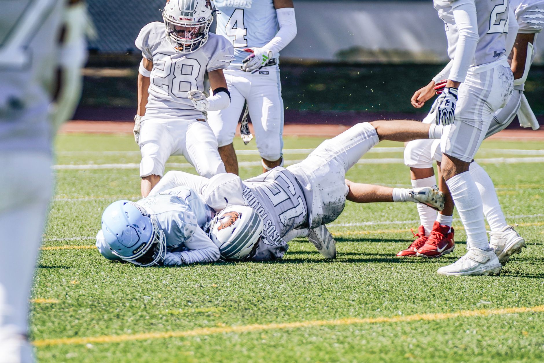 Dynamic action scene of a youth American football game with players in full gear.