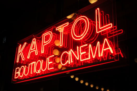 Vibrant neon sign of Kaptol Boutique Cinema glowing at night, creating a retro ambiance.