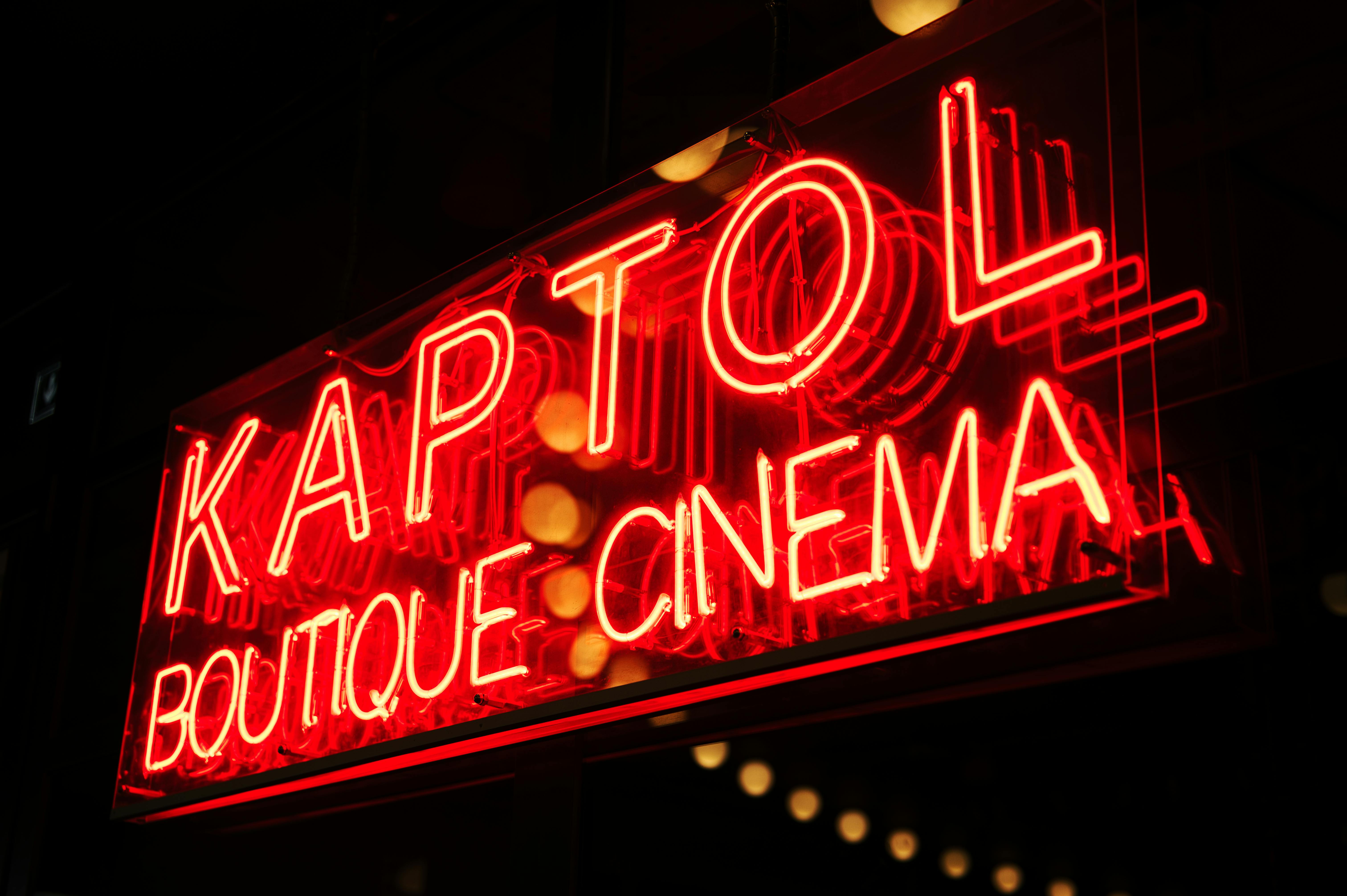 common:alt.prefix Rètol de neó vibrant del Kaptol Boutique Cinema que brilla a la nit, creant un ambient retro. common:alt.postfix