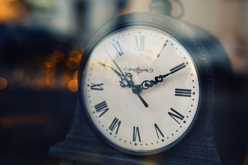 Free Close-up of a vintage clock with Roman numerals, softly lit background. Stock Photo