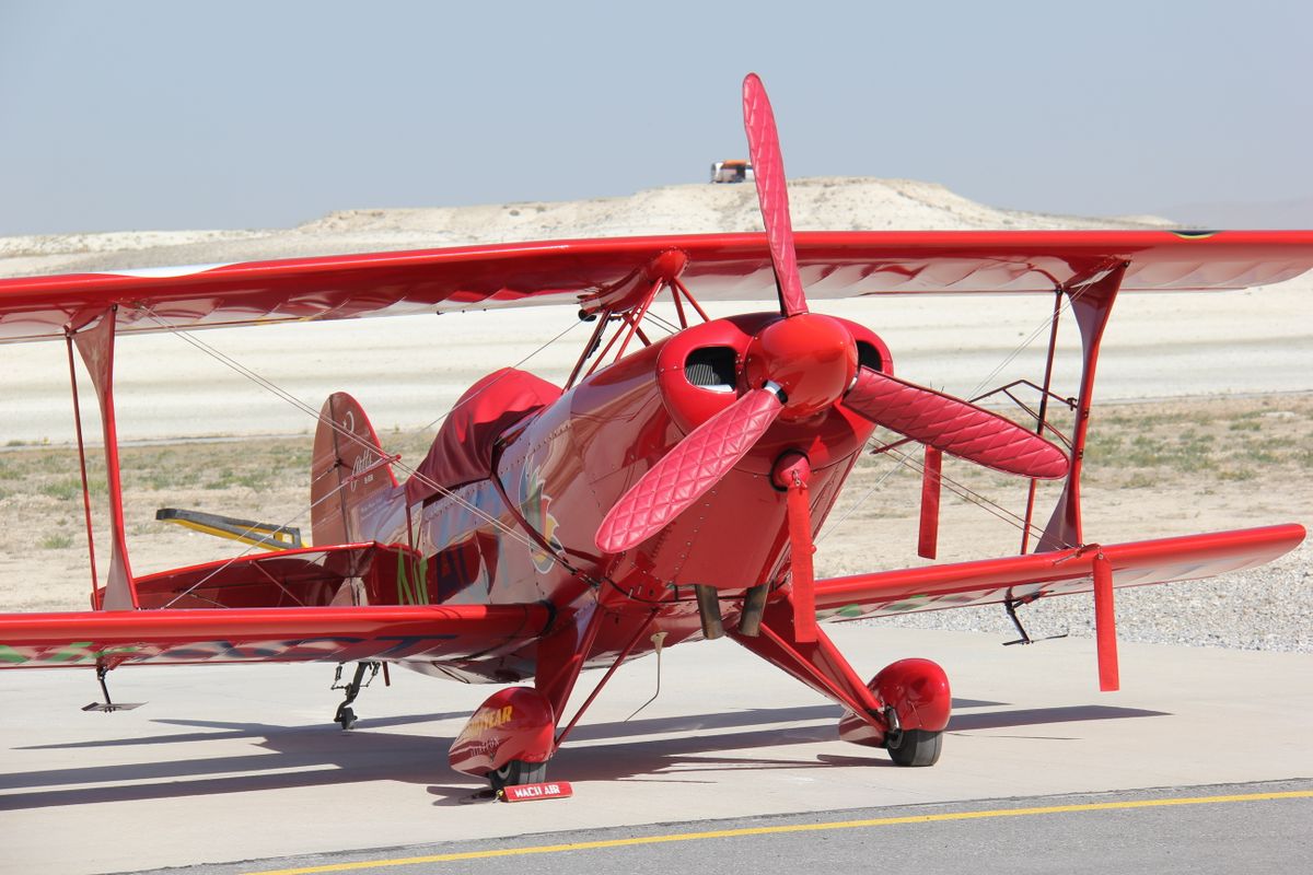 Vintage red biplane on runway — honoring the legacy of female aviators like Bessie Coleman