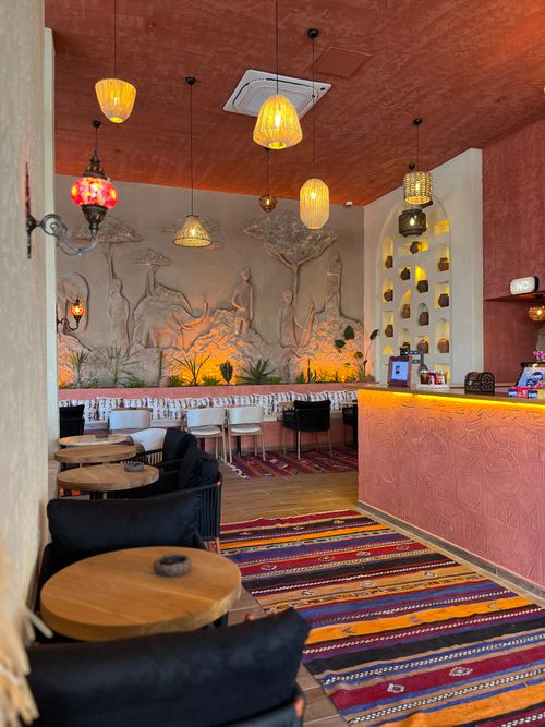 Free Cozy cafe with Moroccan decor features vibrant rugs and ornate wall sculptures. Stock Photo