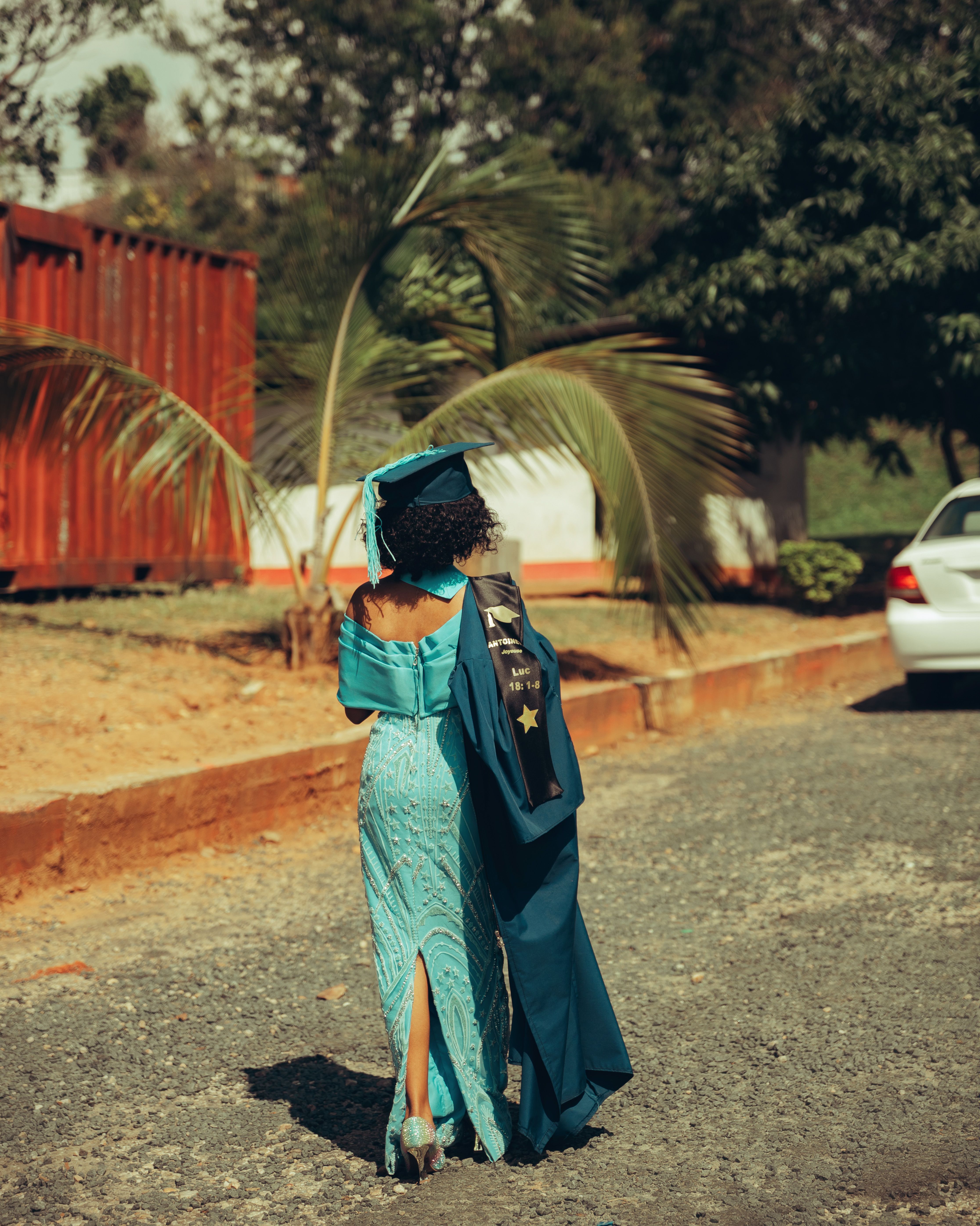 Graduate Walking Outdoors in Cap and Gown · Free Stock Photo