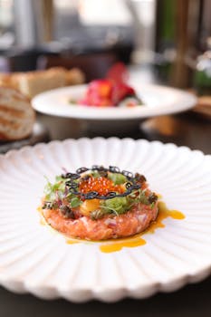 Delicious salmon tartare topped with caviar on a decorative plate, ideal for fine dining visuals.