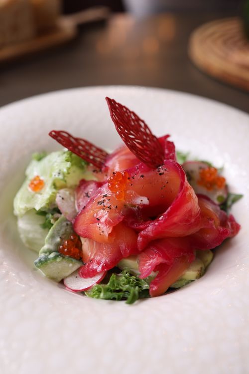 Free Gourmet salad with smoked salmon, avocado, and caviar elegantly plated. Stock Photo