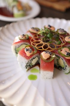 Stylishly presented sushi plate with colorful toppings and artistic arrangement.