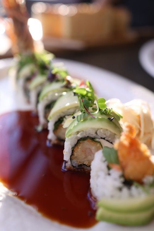 Free Delicious sushi roll with avocado topping and soy sauce, perfect for culinary enthusiasts. Stock Photo
