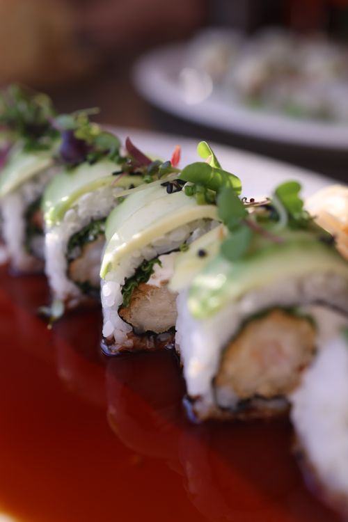 Free Close-up of a delicious sushi roll topped with fresh avocado and microgreens. Stock Photo