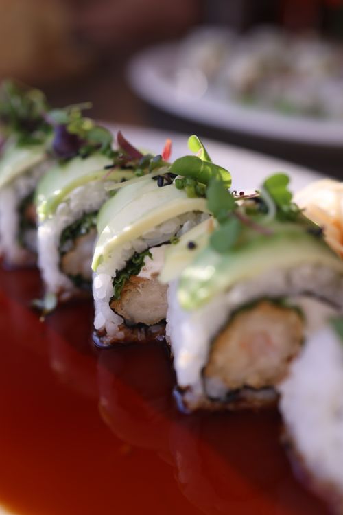 Free Delicious sushi roll close-up featuring avocado and microgreens on a glossy plate. Stock Photo