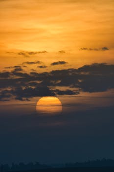 Captivating sunrise over Poprad, Slovakia, with vibrant gold and orange hues casting light through the clouds.