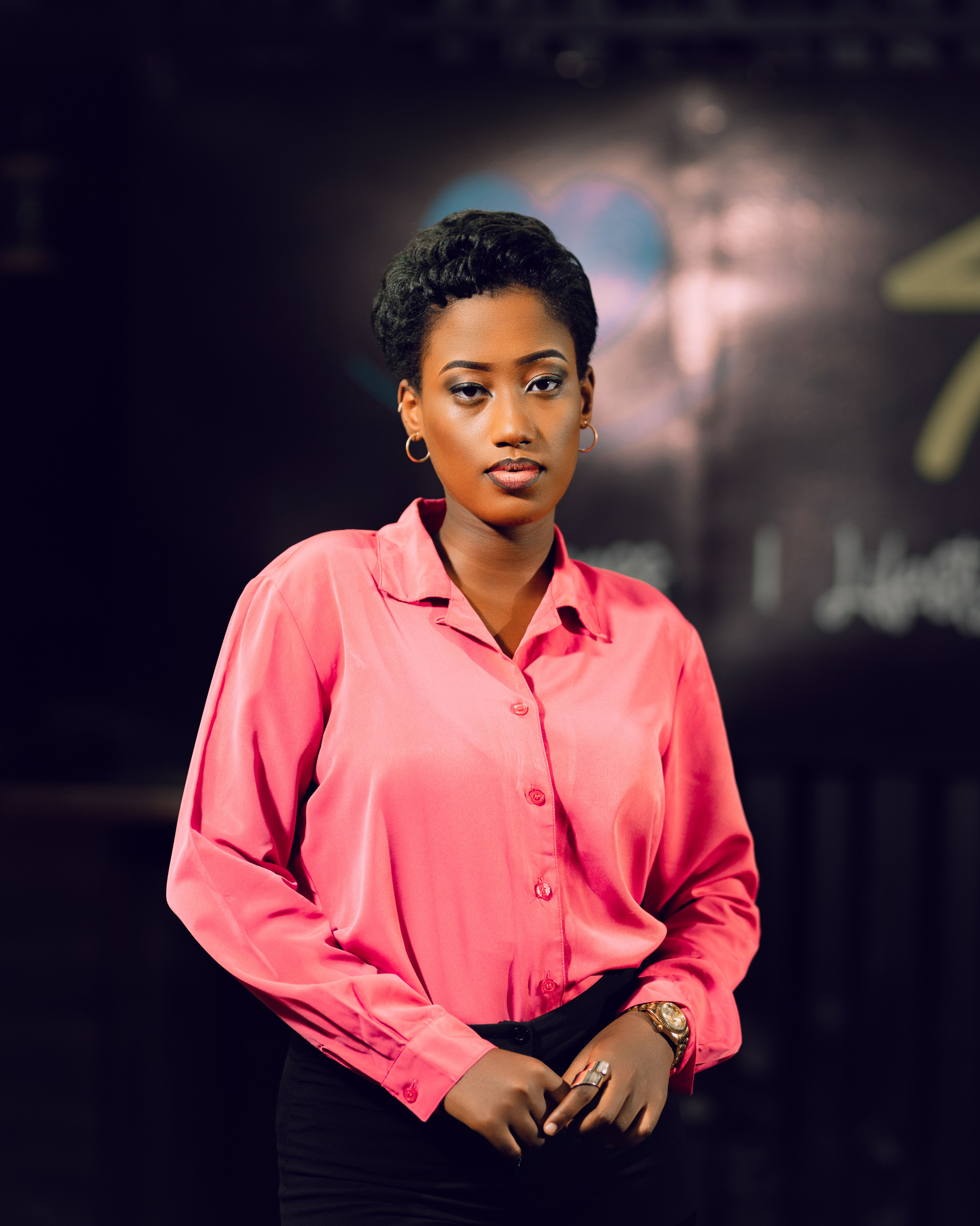 Elegant portrait of a young woman wearing a pink shirt indoors. Professional and poised.