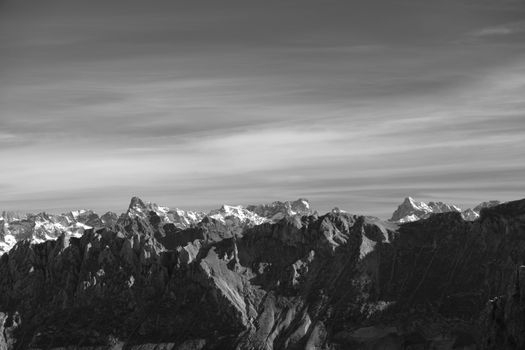 A breathtaking black and white photograph of a mountain range under a vast sky.