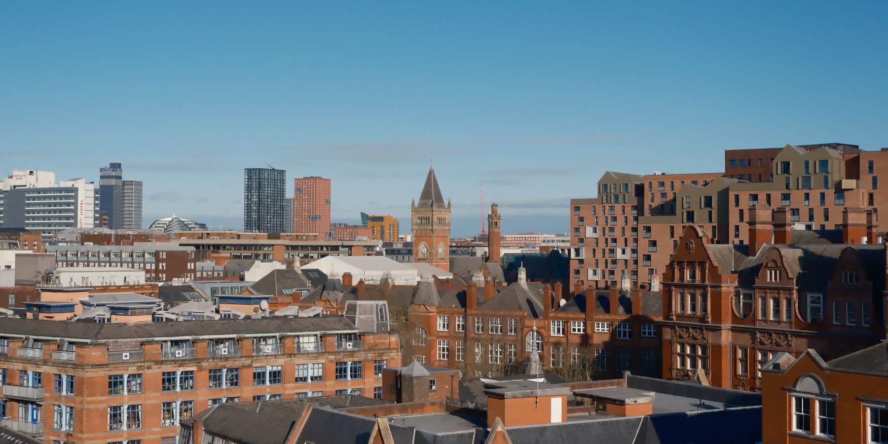 A vibrant view of Manchester showcasing modern and classic architecture under a clear sky.