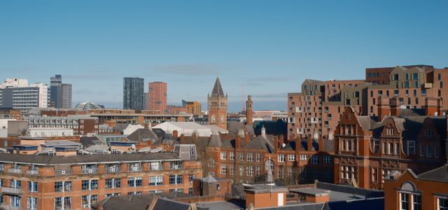 A vibrant view of Manchester showcasing modern and classic architecture under a clear sky.