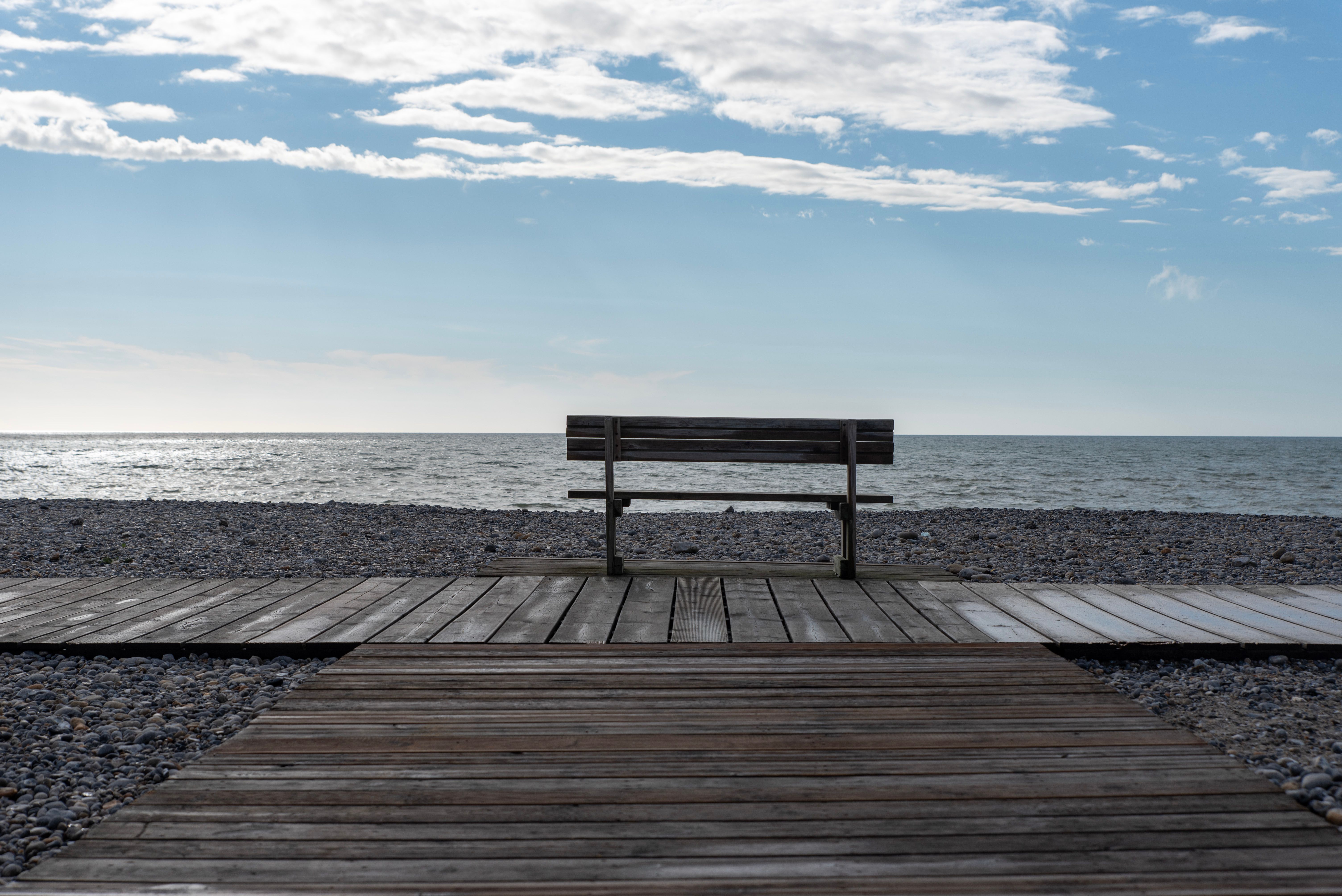 Serene Beachfront Bench with Open Sea View · Free Stock Photo