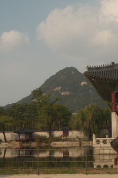 Capture of traditional Korean architecture with a mountain backdrop in Seoul, South Korea.