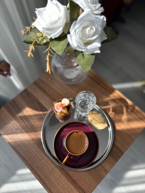 Free Top view of a stylish coffee setup featuring roses, a cup of coffee, and a cookie. Stock Photo
